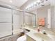 Cozy bathroom features a glass-enclosed shower and tub combo, a large mirror, and vanity with counter space at 112 Coventry Ln, Haines City, FL 33844