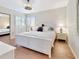 Inviting bedroom with wood-look floors, a shuttered window, and a crisp white color scheme at 112 Coventry Ln, Haines City, FL 33844