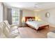 Cozy bedroom with wood floors, a queen bed, sitting area, and view of the outdoors at 112 Coventry Ln, Haines City, FL 33844