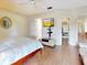 Well-lit bedroom featuring wood floors, a tv, ensuite access, and walk-in closet access at 112 Coventry Ln, Haines City, FL 33844