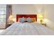 Comfortable main bedroom featuring wood floors, nice lamps, and a decorative headboard at 112 Coventry Ln, Haines City, FL 33844