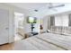 Bright main bedroom featuring a tv, wood flooring, sitting area, and ensuite bathroom access at 112 Coventry Ln, Haines City, FL 33844