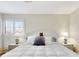 Bright bedroom boasts white shutters, a plush bed with decorative pillows, and matching bedside tables with lamps at 112 Coventry Ln, Haines City, FL 33844