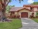 Beautiful exterior of a home showcasing a garage and colorful front landscaping and a clay tile roof at 112 Coventry Ln, Haines City, FL 33844