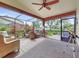 Relaxing screened lanai with comfortable seating, a ceiling fan, and lush landscaping views at 112 Coventry Ln, Haines City, FL 33844