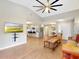 Open-concept living space blending the living room and kitchen, with hardwood floors, ceiling fan, and television at 112 Coventry Ln, Haines City, FL 33844