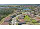 Scenic aerial view of a residential area featuring houses, a small lake and lush greenery at 1158 Oak Bluff Dr, Davenport, FL 33837