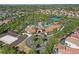 Aerial view of the community entrance, a resort-style pool area, and various residences and tennis courts at 1158 Oak Bluff Dr, Davenport, FL 33837