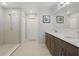 Bright bathroom featuring a double sink vanity, a glass enclosed shower, and neutral tiling throughout at 1158 Oak Bluff Dr, Davenport, FL 33837