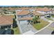 Two-story home with a gray exterior, a brick driveway and a well-manicured lawn with palm trees at 1158 Oak Bluff Dr, Davenport, FL 33837