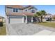 Charming home with a two-car garage, featuring a well-kept lawn and front garden at 1158 Oak Bluff Dr, Davenport, FL 33837