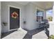 Inviting front porch with chairs, a wreath on the door, and neat landscaping at 1158 Oak Bluff Dr, Davenport, FL 33837