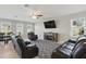 Inviting living room featuring a fireplace, large screen TV, and comfortable seating with backyard views at 1158 Oak Bluff Dr, Davenport, FL 33837