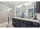 Elegant bathroom featuring a glass shower, double vanity with granite countertop and stylish lighting fixtures at 1284 Pavia Dr, Apopka, FL 32703