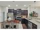Modern kitchen features granite countertops, stainless appliances, dark wood cabinets, and center island with seating at 1284 Pavia Dr, Apopka, FL 32703