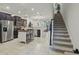 Open-concept kitchen features stainless steel appliances, island, and adjacent staircase at 1284 Pavia Dr, Apopka, FL 32703