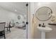 Modern living room with a white sectional couch, tile flooring, and an adjacent half-bathroom at 1284 Pavia Dr, Apopka, FL 32703
