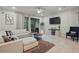 Living room with comfy sectional sofa, TV, and sliding doors accessing the screened-in patio at 1284 Pavia Dr, Apopka, FL 32703