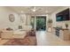 Bright living room with tile floors, comfy white sectional couch, and sliding glass doors to the patio at 1284 Pavia Dr, Apopka, FL 32703