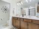 Bathroom featuring double sinks, wood cabinets, decorative mirror and a separate toilet room at 14432 Orchid Island Dr, Orlando, FL 32827