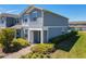 Well-maintained townhome with blue siding, manicured landscaping, and paved walkway at 14432 Orchid Island Dr, Orlando, FL 32827