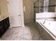 The primary bathroom has marble floors, a separate shower, and a soaking tub for ultimate relaxation at 1584 Plunker Dr, Davenport, FL 33896