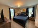 Relaxing bedroom features a king-sized bed, dark blue bedding, and two bedside tables at 1584 Plunker Dr, Davenport, FL 33896