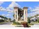 Community entrance featuring elegant signage, landscaping, and architectural details at 1584 Plunker Dr, Davenport, FL 33896