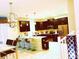 Modern kitchen features dark wood cabinets, stainless steel appliances, and a breakfast bar at 1584 Plunker Dr, Davenport, FL 33896