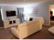 Cozy living room features neutral tones, modern white furniture, and a large television at 1584 Plunker Dr, Davenport, FL 33896