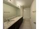 Bathroom boasts double sinks with a granite countertop, large mirror and tiled floors at 15872 Moonlight Bay St, Winter Garden, FL 34787