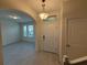 Bright foyer features stylish light fixture, neutral walls, and an arched entryway leading to the living area at 15872 Moonlight Bay St, Winter Garden, FL 34787