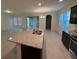 Kitchen island boasts a double sink and granite countertops, with a view of the open floor plan at 15872 Moonlight Bay St, Winter Garden, FL 34787