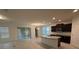 Open floor plan showcasing a kitchen with an island, dark cabinets, granite countertops, and stainless steel appliances at 15872 Moonlight Bay St, Winter Garden, FL 34787