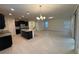 Open floor plan with kitchen island and stainless appliances, and living room featuring bright, neutral paint and tile floor at 15872 Moonlight Bay St, Winter Garden, FL 34787