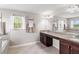 Bright bathroom featuring double sinks, granite countertops, a mirror, and a window with lots of light at 1628 Thetford Cir, Orlando, FL 32824