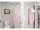 Bathroom featuring a toilet, shower with floral curtain and pink towels on a towel rack at 1628 Thetford Cir, Orlando, FL 32824