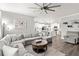 Cozy living room with kitchen view, featuring a plush sectional, round coffee table, and natural light at 1628 Thetford Cir, Orlando, FL 32824