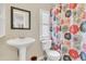 Bright bathroom featuring a pedestal sink, floral shower curtain, and natural light from the window at 18302 15Th Ave, Orlando, FL 32833