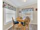 Charming dining area featuring a round wood table, bright windows, and unique floral valances at 18302 15Th Ave, Orlando, FL 32833