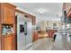 Well-lit kitchen showcasing stainless steel appliances, wood cabinets, and open layout with view into living area at 18302 15Th Ave, Orlando, FL 32833