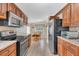 Spacious kitchen with modern appliances, wooden cabinetry, stone countertops, and adjacent dining area at 18302 15Th Ave, Orlando, FL 32833