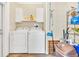 Well-lit laundry room with updated washer, dryer, utility sink, and overhead storage at 18302 15Th Ave, Orlando, FL 32833