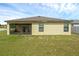 The backyard of this home features a covered patio and lush lawn at 1924 Piedmont Ct, Mascotte, FL 34753