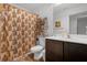 Functional bathroom with vanity, mirror, and a decorative shower curtain providing privacy at 1924 Piedmont Ct, Mascotte, FL 34753