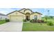 Charming one-story home with a well-manicured lawn and attached two-car garage on a sunny day at 1924 Piedmont Ct, Mascotte, FL 34753