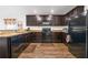 Functional kitchen featuring granite countertops, wooden cabinets, black appliances and durable wood-look flooring at 1924 Piedmont Ct, Mascotte, FL 34753
