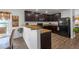 Inviting kitchen area featuring a breakfast bar, granite countertops, and stylish dark wood cabinetry at 1924 Piedmont Ct, Mascotte, FL 34753