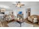 Open living room with hardwood floors, comfortable seating, a ceiling fan, and a view into the dining and kitchen areas at 1924 Piedmont Ct, Mascotte, FL 34753