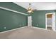 Green bedroom featuring carpet, ceiling fan, and an open doorway to the bathroom at 205 Twisting Trl, Orlando, FL 32825